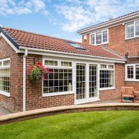 Modern Sunroom or conservatory extending into the garden, surrounded by a block paved patio