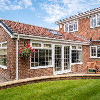 Modern Sunroom or conservatory extending into the garden, surrounded by a block paved patio